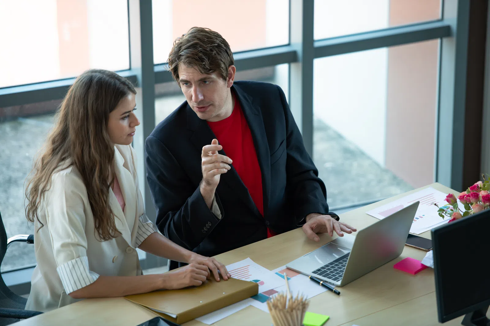 a man and a woman looking at a laptop