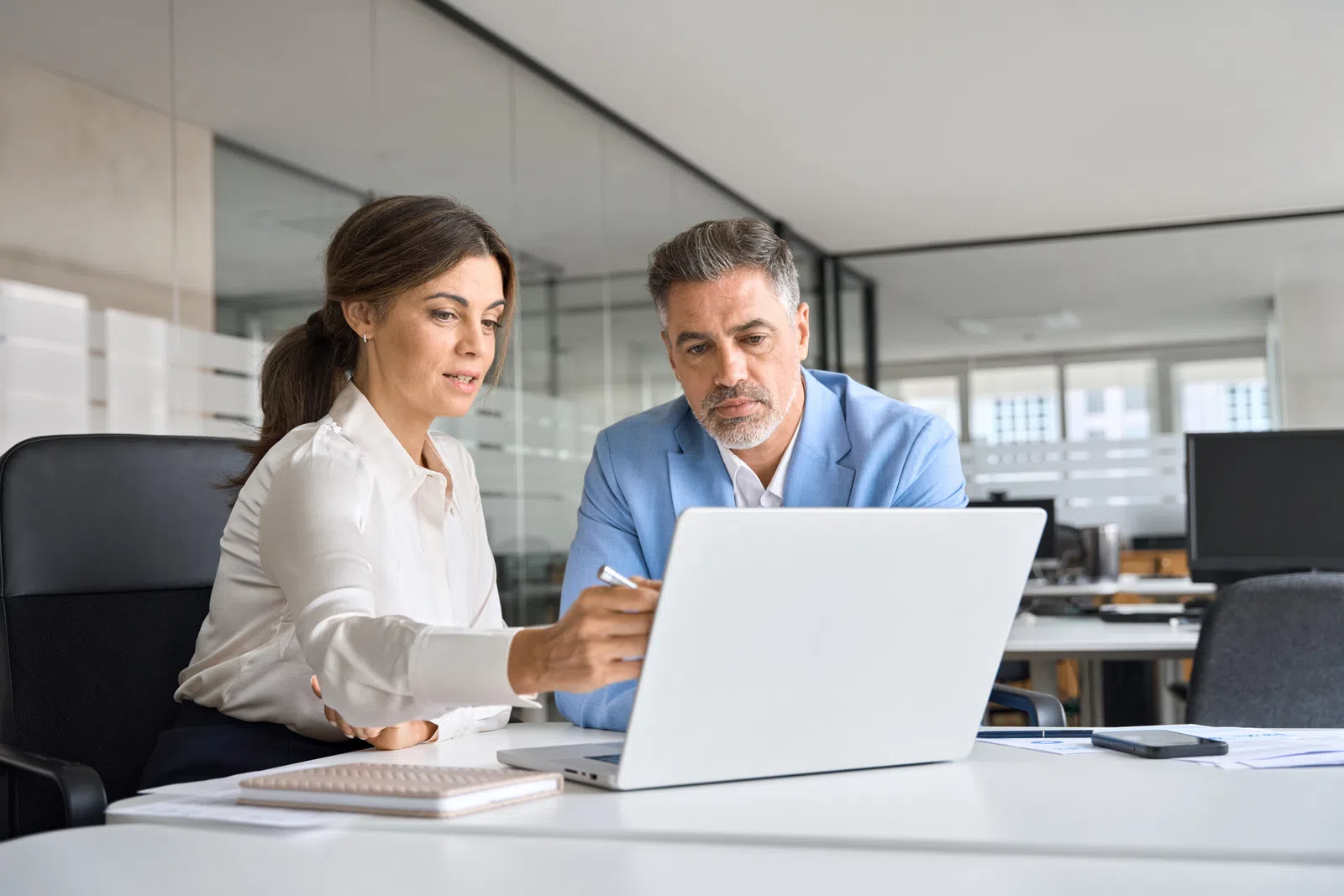 a man and a woman looking at a laptop